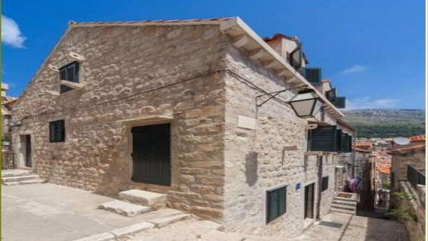 Ein Steinhaus mit einem kleinen Eingang und Stufen, die dorthin führen.