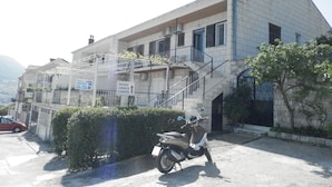A building with a staircase, a motorcycle, and a hedge. - Guest House Bridge View - Double Room with Balcony and Sea View (Dubrovnik)