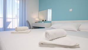 A hotel room with a neatly made bed, a bedside table with a lamp, a mirror, and a view of the outdoors through sheer curtains. - Dva Galeba - One Bedroom Apartment with Garden Terrace (202) (Bol)