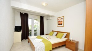 A bedroom with a bed, bedside table, and a television on a stand. - Apartments Villa Moonlight - Two Bedroom Apartment with Sea View Terrace (Okrug Gornji)