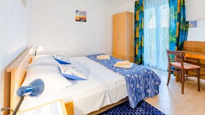 Une chambre avec deux lits, un bureau, une chaise et une armoire.