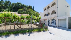 Ein Gebäude mit weißer Fassade, Rundbogenfenstern und einem Schild, das eine Marina kennzeichnet.