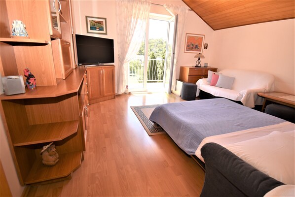 A bedroom with a bed, a TV, wooden furniture, and a balcony with a view. - Guest House Kanjuo - Two Bedroom Apartment with Terrace and Garden View (Mlini)