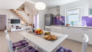 A modern kitchen with white cabinets, a built-in oven, and a window with a view. - Villa Blue Sky - Three Bedroom Villa with Pool (Bol)