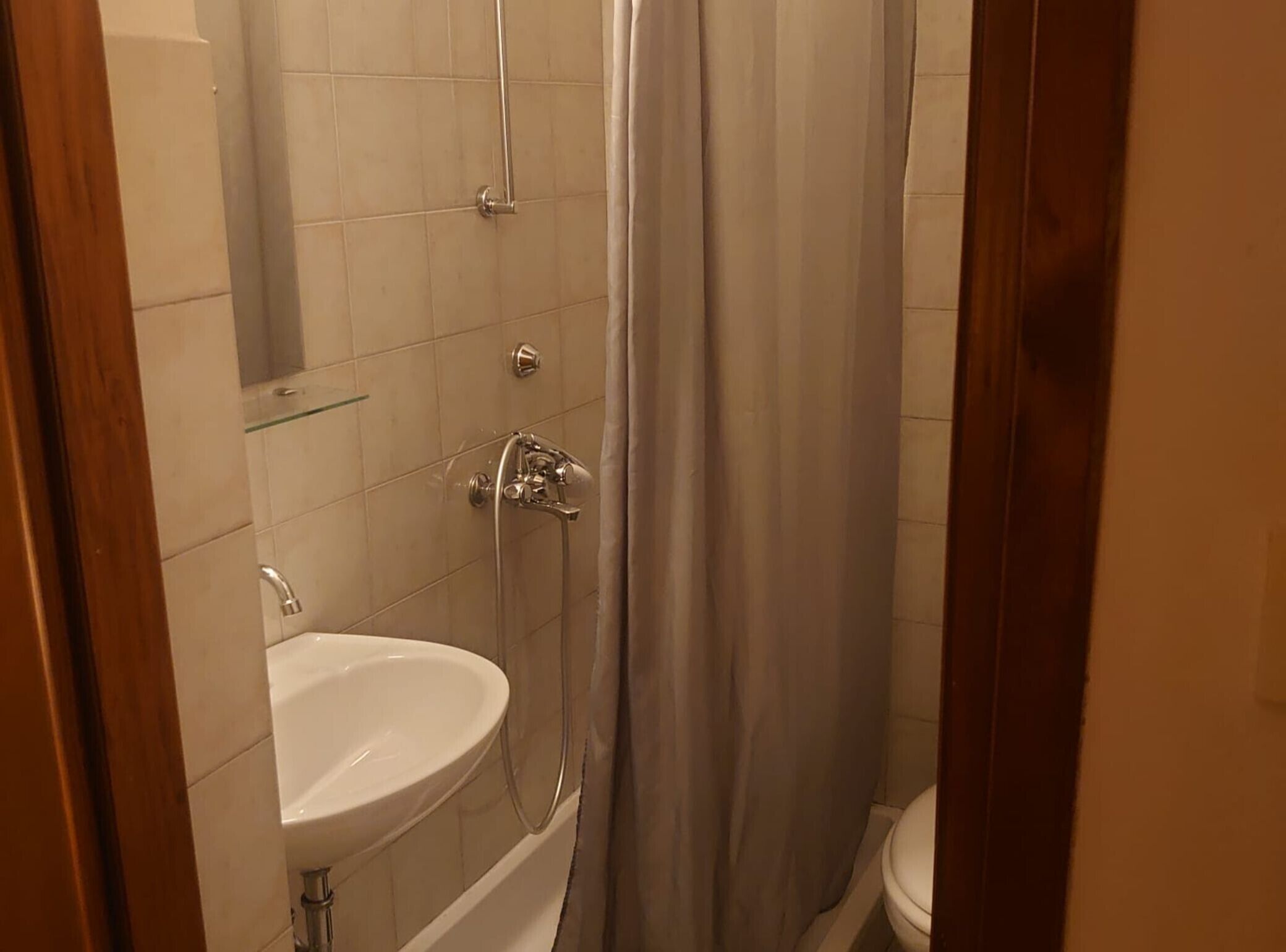 A bathroom with a white sink, a shower with a glass enclosure, and a toilet.