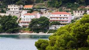 A coastal town with buildings along the shoreline, a beach, and dense greenery. - Apartmetns Franka Saplunara-One-Bedroom Apartment with Terrace and Sea View No2 (Saplunara)