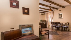 A cozy living room with a wooden bench, a vintage radio, and a painting of a boat on the wall.