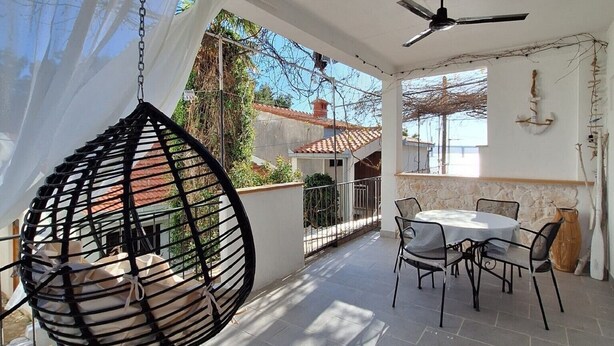 A sunlit patio with a hanging chair, a table with chairs, and a ceiling fan. - Apartments Mediterranean House - Two Bedroom Apartment with Terrace (Klek)