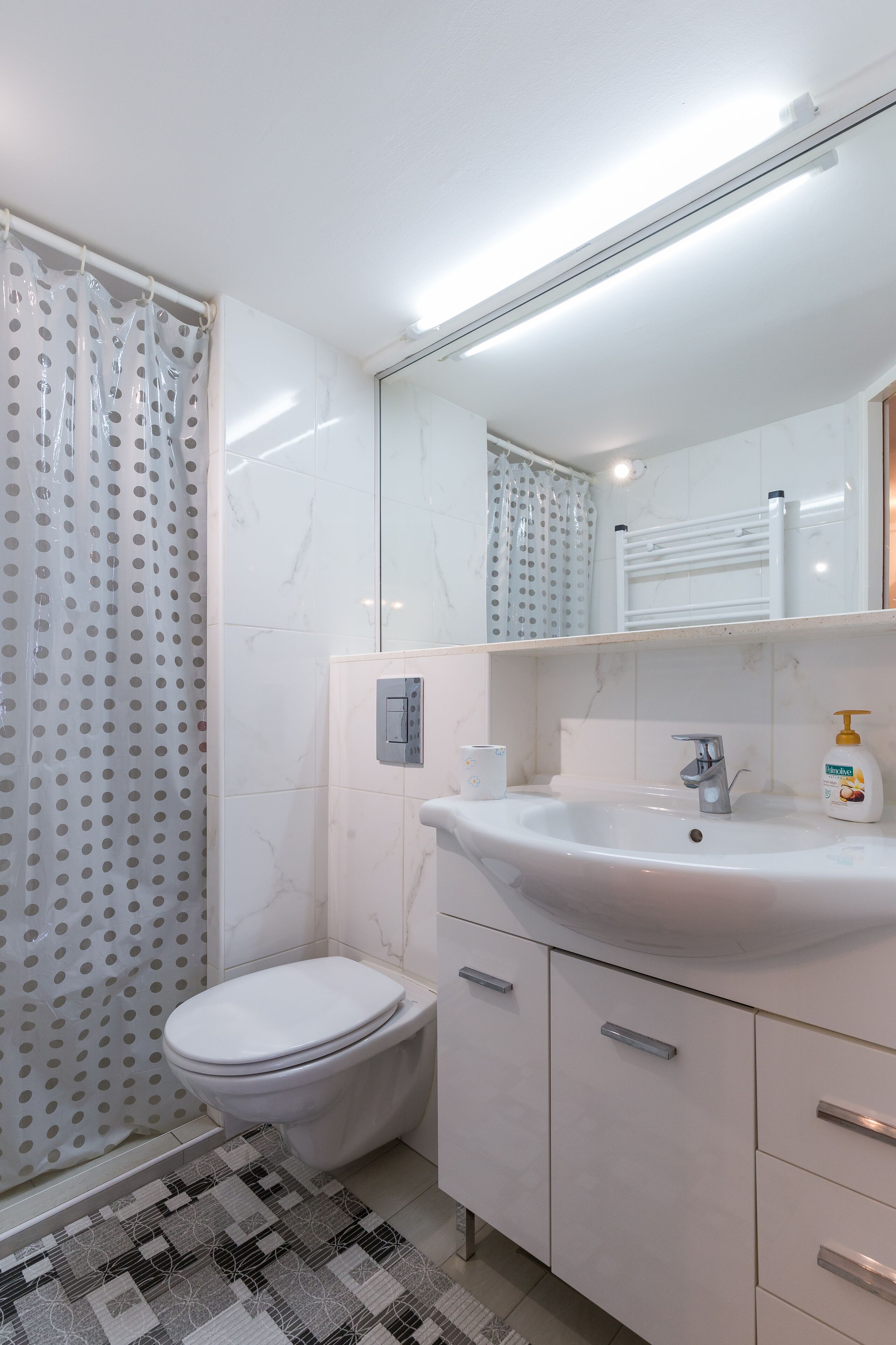 A bathroom with a toilet, sink, and shower.