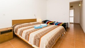 Une chambre avec deux lits, une table de chevet et une lampe.