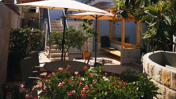 A patio area with a round table, outdoor seating, and a pergola. - Apartments Natasa- One Bedroom Apartment with Balcony (Supetar)