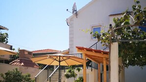 A building with a satellite dish, a balcony with a pergola, and a red-tiled roof. - Apartments Natasa- One Bedroom Apartment with Balcony (Supetar)