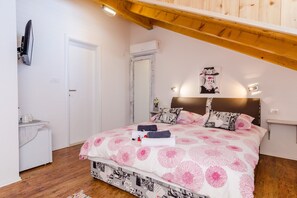 A bedroom with a bed, bedside tables, a mirror, and a ceiling fan.