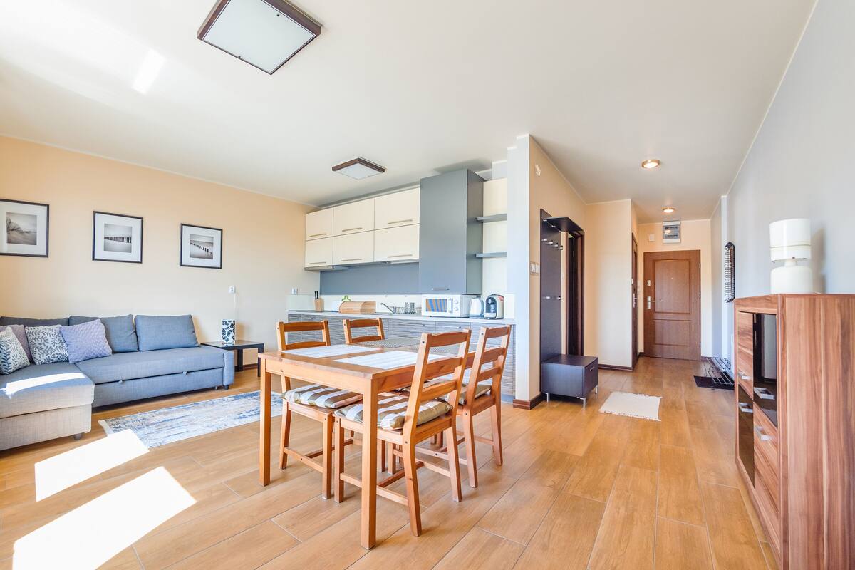 Eine moderne Wohnung mit Wohnzimmer, Essbereich, Küche und einem kleinen Flur.