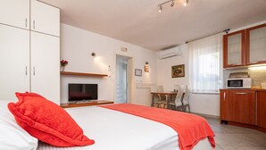 Une chambre d’hôtel équipée d’un lit, d’une télévision, d’un bureau et d’une kitchenette.
