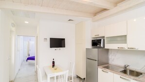 A modern kitchen with white cabinets, a stainless steel refrigerator, and a built-in microwave. - Apartment Riki - Studio Apartment with Balcony and City View (Dubrovnik)