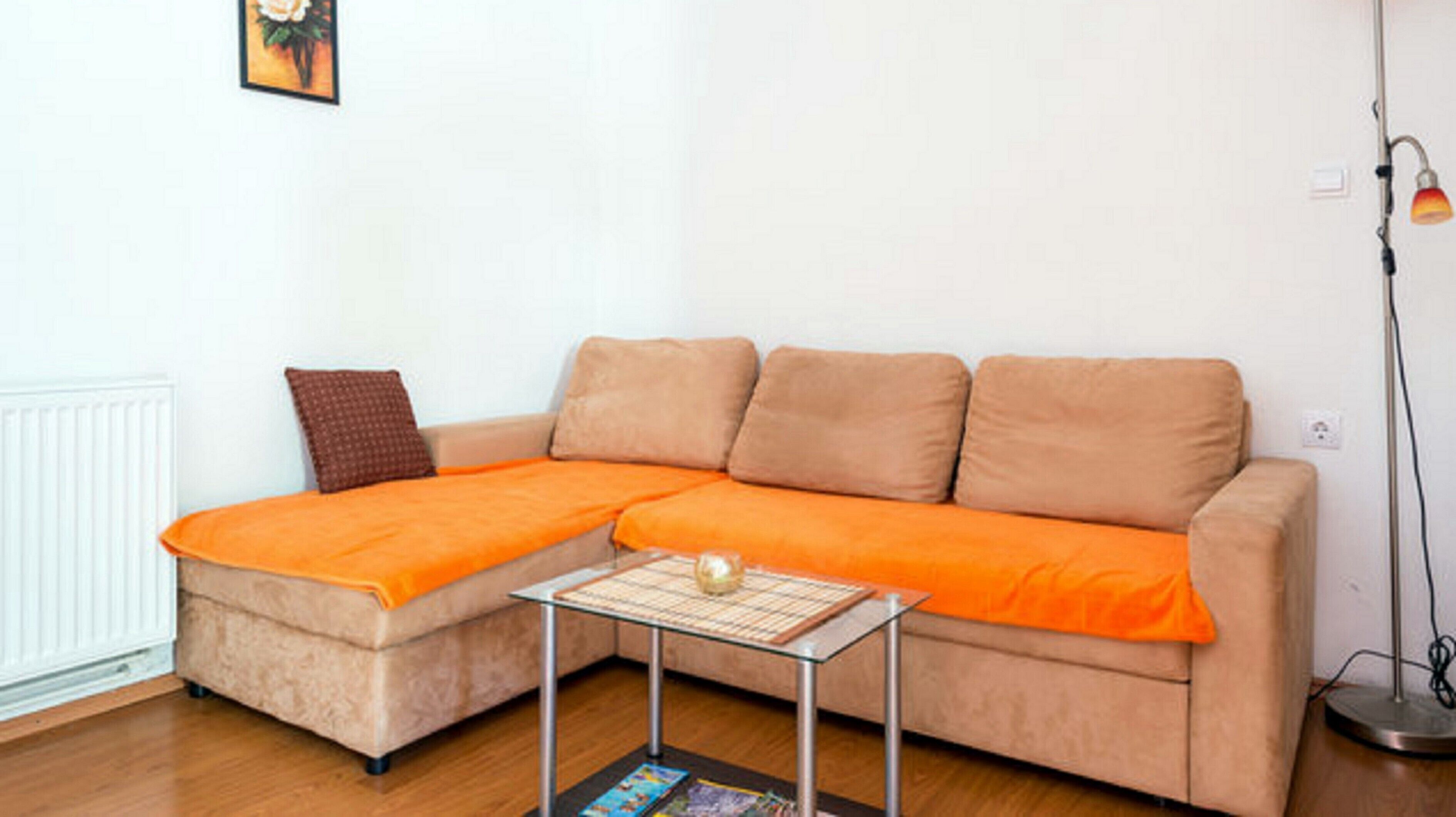 A living room with a sofa, a small table, and a floor lamp.