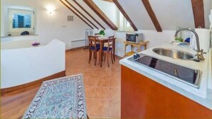 Eine Küche mit modernem Design, ausgestattet mit einem Backofen, einer Spüle und einem Essbereich mit Tisch und Stühlen.