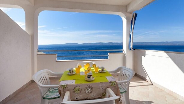 Ein Balkon mit Tisch für zwei Personen, mit Blick auf das Meer.