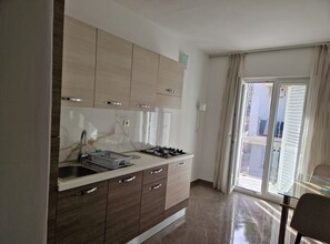 A modern kitchen with a gas stove, sink, and wooden cabinets.