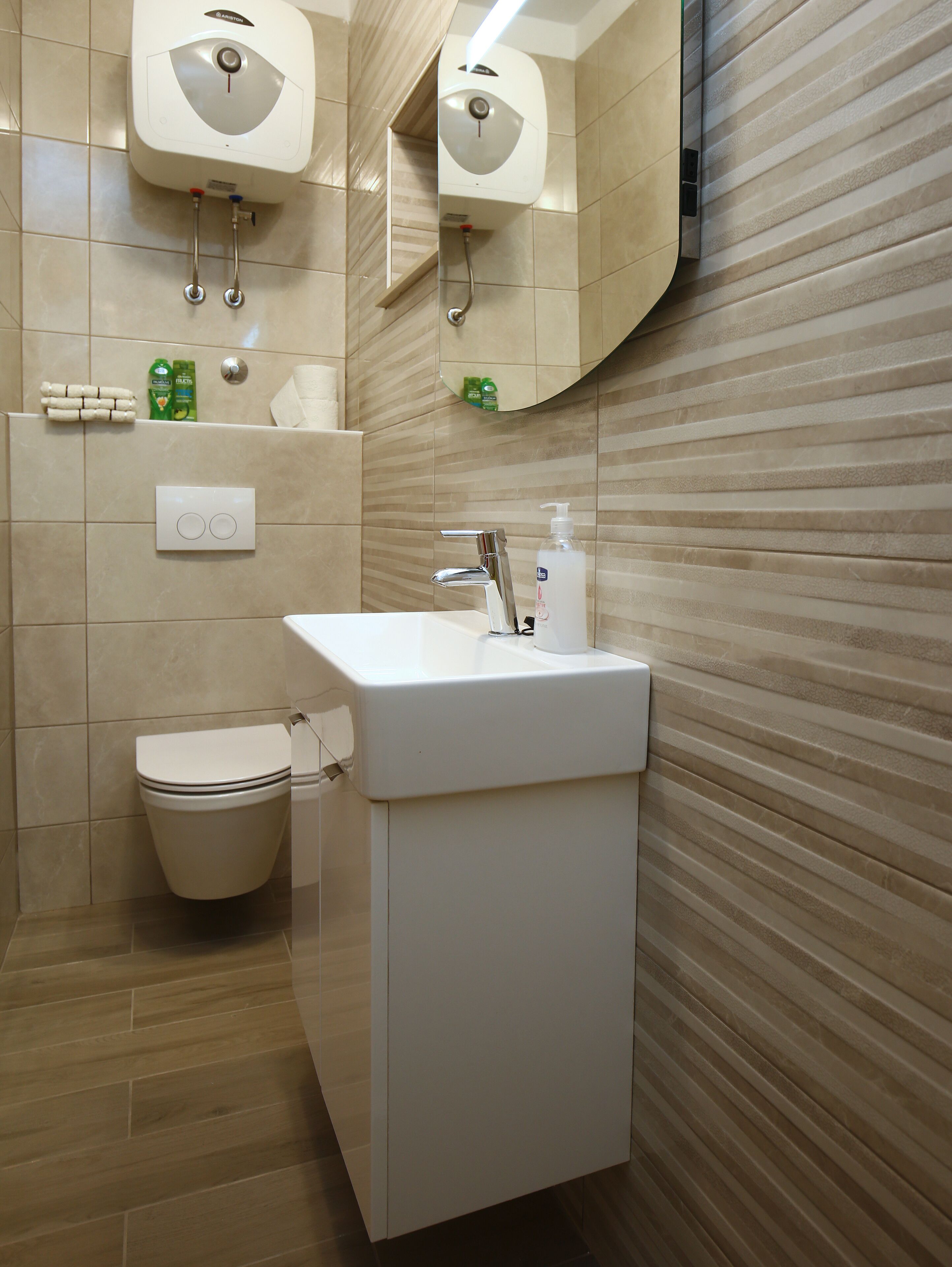 Een moderne badkamer met toilet, wastafel en spiegel.