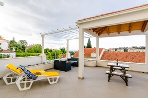 A rooftop terrace with lounge chairs, a table, and a pergola. - Miracle Apartments - Comfort Studio Apartment with Terrace and City View (Dubrovnik)