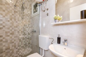 A modern bathroom with a shower, toilet, and sink. - Miracle Apartments - Comfort Studio Apartment with Terrace and City View (Dubrovnik)