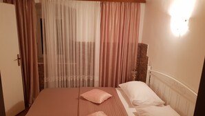 A bedroom with a bed, two pillows, a nightstand, and a lamp. - Apartments Minerva - One Bedroom Apartment No.1 (Dubrovnik)