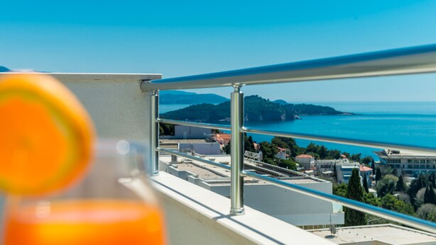 Un balcon offrant une vue dégagée sur la mer et les collines lointaines.