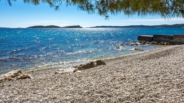 A pebble beach with clear blue water and distant islands. - Holiday Home Lido - Three Bedroom Holiday House with Terrace (Orebic)