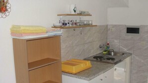 Une cuisine de taille réduite, équipée d’un évier, d’un plan de travail et d’un meuble en bois.