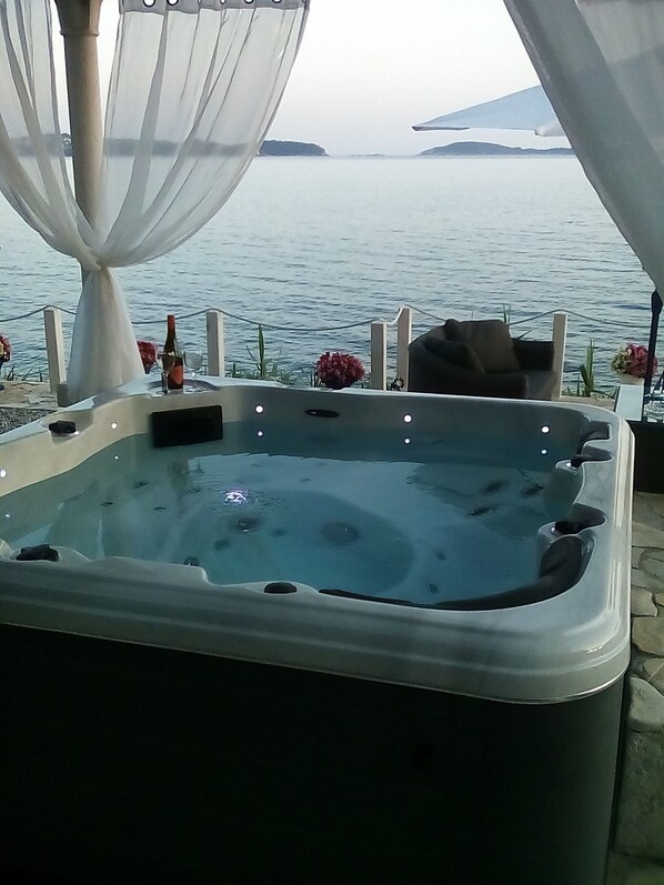 A hot tub with a view of the sea and a mountain in the background.
