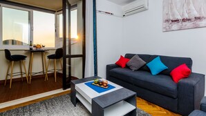 Ein modernes Wohnzimmer mit einer Couch, einem Couchtisch und einem Essbereich mit Stühlen und einem Tisch.