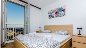 Ein Schlafzimmer mit einem großen Bett, einem Nachttisch, einem Beistelltisch und einem Bild an der Wand.