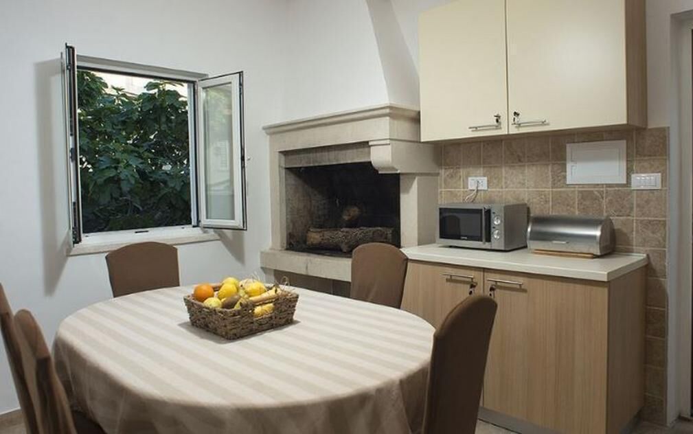 A compact kitchen with a dining table, a microwave, and a fireplace.
