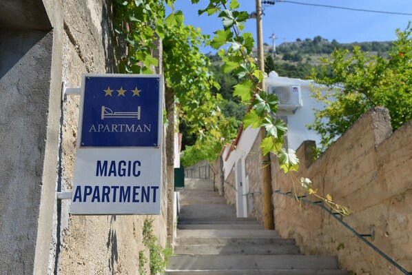A sign for a building labeled 'MAGIC APARTMENT' with a staircase leading up to it.