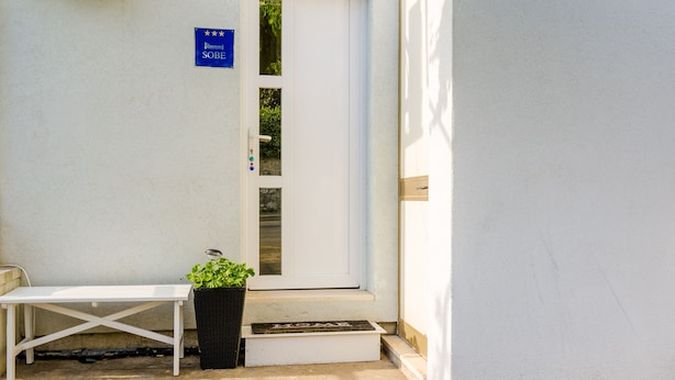 A white door with a blue sign above it, a white bench, and a potted plant on the steps. - The Point Room - Double Room with City View (Dubrovnik)