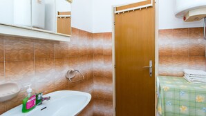 Une salle de bain équipée d’un lavabo, de toilettes et d’un espace douche.