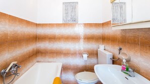 Une salle de bain avec une baignoire, des toilettes et un lavabo.