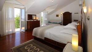 Ein Schlafzimmer mit einem großen Bett, einem Schminktisch, einem Spiegel und einem Nachttisch mit einer Lampe.