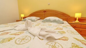 A neatly made bed with a compass-themed bedspread, two bedside lamps, and a wooden headboard. - Apartments Villa Michele-Three Bedroom Apartment with Partial Sea View ( Grejp ) (Orebic)