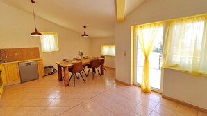 A spacious kitchen with a dining area, featuring a dishwasher, a sink, and a window with curtains. - Apartments Villa Michele-Three Bedroom Apartment with Partial Sea View ( Grejp ) (Orebic)