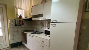 A compact kitchen with white cabinets, a microwave, and a sink. - Apartments Mavi - Studio Apartment with Terrace and City View (Dubrovnik)
