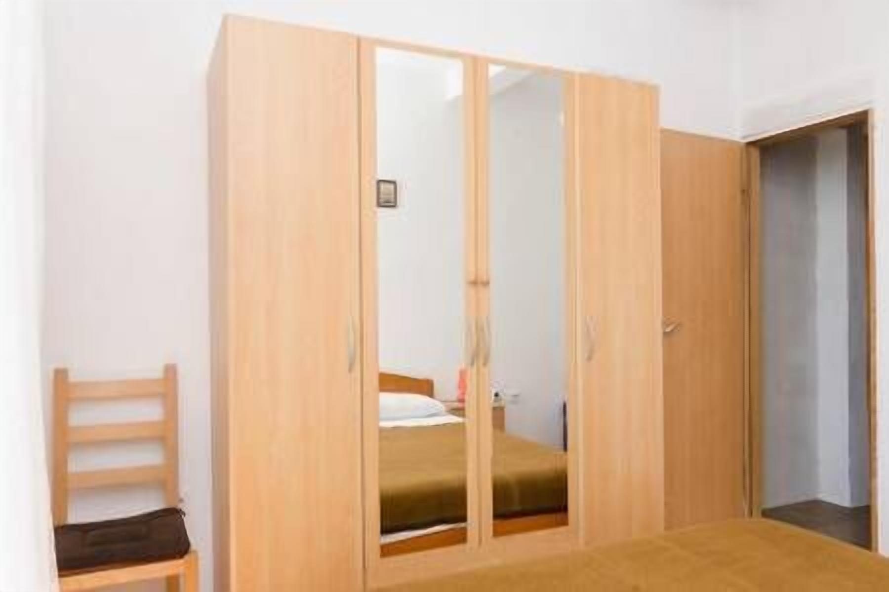 Una camera da letto con un armadio in legno, un letto e una sedia.
