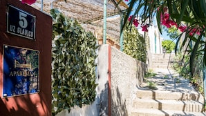 Uma escadaria leva a um prédio com uma placa indicando '5 Uz Glavicu' e 'Apartman'.