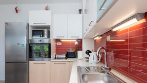 Een moderne keuken met roestvrijstalen apparatuur, een magnetron en een broodrooster.
