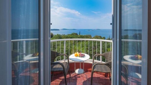 A balcony with a table and chairs, overlooking a body of water and greenery. - Villa Panorama Dubrovnik - Comfort One Bedroom Apartment with Balcony and sea View (Mlini)