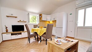 A compact living space with a dining area, kitchenette, and a sofa. - Apartments Memunić - Standard One Bedroom Apartment with Partial Sea View (Ston)