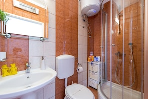 Ein Badezimmer mit Waschbecken, Toilette, Dusche und Handtuchhalter.