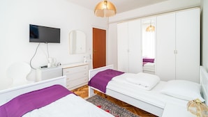 A modern bedroom with two beds, a television, a wardrobe, and a mirror. - Apartments Peco - Four Bedroom Apartment with Balcony and Sea View (Mokosica)